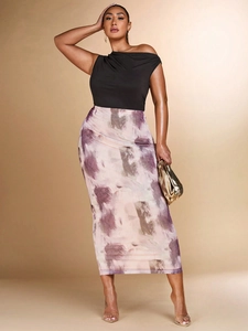 Detail of elegant black off-shoulder top with draped neckline and abstract art print skirt