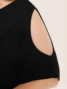Detail of elegant black knit top featuring cold-shoulder cutout and round neckline detail