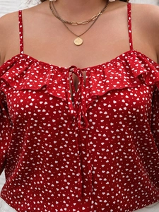 Detail of red camisole top with white heart polka dots and ruffled neckline lace-up design