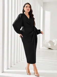 Detail of elegant black wrap dress featuring a deep V-neck and stylish lantern sleeves