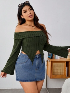 Close-up of dark green ribbed knit top with bell sleeves and irregular jagged hemline