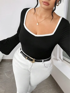Slim fit black long sleeve knit top with white contrast U-neckline and bell sleeves