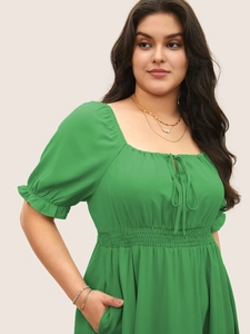 Gros plan de la robe verte grande taille avec encolure carrée et manches bouffantes