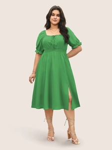 Vue de face robe verte avec encolure carrée, manches bouffantes et fente latérale
