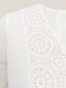 Elegant white V-neck dress with intricate lace embroidery and ruffled texture