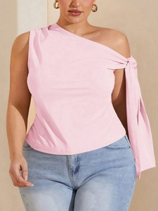 Detailed close-up of the pink one-shoulder top with an elegant knot and draped fabric