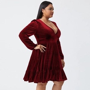 Detail of burgundy velvet dress featuring deep V-neckline and elegant layered ruffle hem