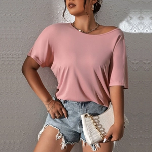 Pink crew neck short sleeve knit T-shirt paired with light blue denim shorts and white handbag