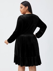 Close-up of black velvet dress fabric showing waist pleats and ruffle hem detail