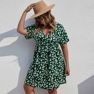 Détail d'une robe grande taille vert foncé à motif marguerites et décolleté en V