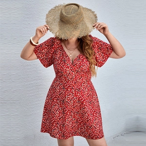 Detail of red floral V-neck dress featuring tiny white and yellow daisy prints on fabric
