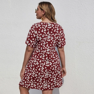 Détail de la robe grande taille rouge vin avec imprimé marguerites vue de dos en extérieur
