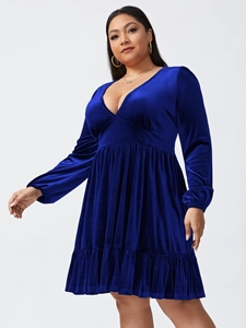 Detailed view of the dark blue velvet texture and ruffled hemline on a V-neck dress