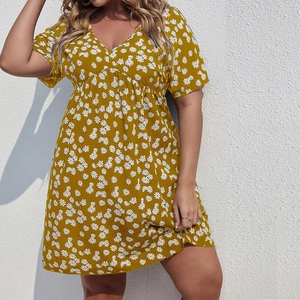 Détail d'une robe d'été grande taille avec imprimé marguerites sur tissu jaune gingembre