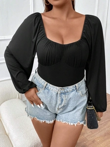 Close-up of black puff sleeve bodysuit featuring a square neckline and ruched bust detail