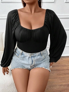 Close-up of black long sleeve bodysuit with square neckline and ruched chest detail