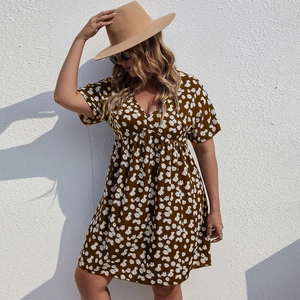 Détail d'une robe d'été à col en V avec imprimé floral marguerite sur fond marron foncé