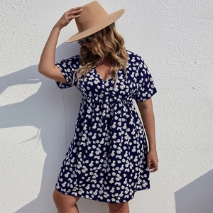 Vue détaillée du col en V et du motif de marguerites blanches sur la robe d'été bleu marine