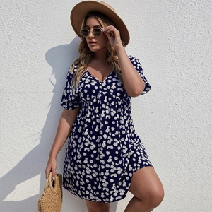 Gros plan sur le décolleté en V et l'imprimé marguerite d'une robe d'été bleu marine