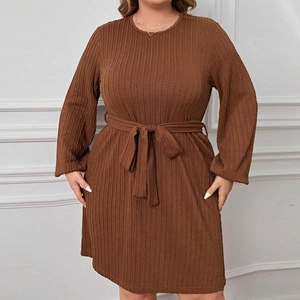 Detail of brown waffle knit long sleeve dress featuring textured fabric and matching waist belt