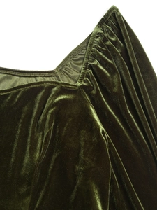 Gros plan du velours vert émeraude montrant des détails plissés et une texture luxueuse