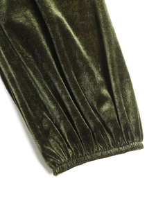 Détail de la manche en velours vert foncé avec poignet élastique et plis délicats