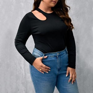Dettaglio della maglia nera a costine a maniche lunghe con scollo asimmetrico cut-out