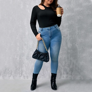 Top nero a maniche lunghe in maglia a coste da donna con spalla scoperta e jeans