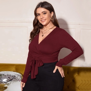 Detail of the V-neck wrap top with an elegant waist tie in deep burgundy knit fabric