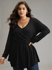 Plus size women's V-neck wrap top with long sleeves and peplum hem in solid black
