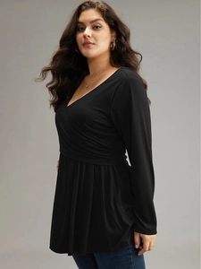 Plus size black V-neck long sleeve top with wrap waist and peplum hem details