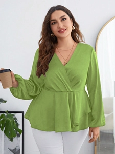 Detail of green V-neck wrap blouse with long puff sleeves and peplum waist design