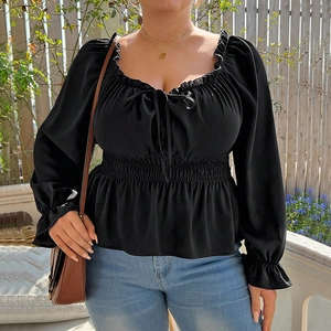 Elegant black puff sleeve square neck top with smocked waist shown in outdoor setting