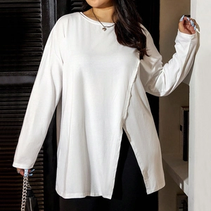Detail of white long sleeve top featuring asymmetric side slit and casual loose fit