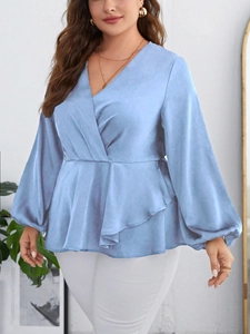 Detailed view of light blue satin V-neck blouse with peplum waist and lantern sleeves