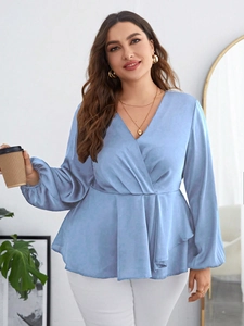 Detail of plus size blue satin wrap blouse showing elegant v-neck and waist drapery texture