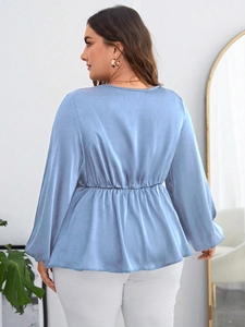 Rear view of light blue satin blouse showing waist cinching and soft texture