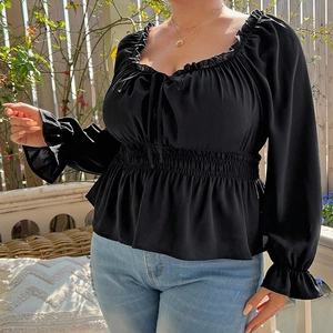 Close-up of black square-neck top featuring ruffled edges and smocked waist detail