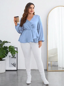 Detail of light blue satin wrap top with V-neck, cinched waist and elegant lantern sleeves