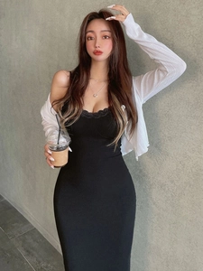 Eng anliegendes schwarzes Spitzenkleid mit weißer Strickjacke für einen schicken Look