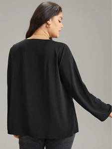 Haut élégant noir à manches longues et col en V pour femme avec coupe fluide