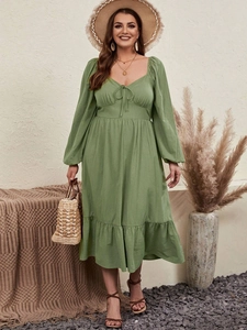 Detailed view of the sweetheart neckline with tie and puff sleeves on this sage green dress