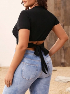 Slim fit black backless crop top with tie-up detail and light blue skinny jeans