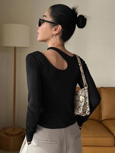 Haut ajusté noir à manches longues avec découpe asymétrique et design épuré