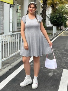 Grey mini dress with ruffle sleeves and bow detail shown on a model in an outdoor setting