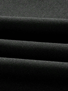 Close-up of black ribbed knit fabric showing high-quality vertical texture and soft drape