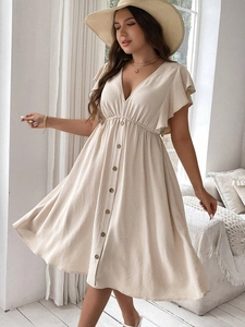 Close-up of beige V-neck dress featuring button details and ruffled sleeves in a summer style