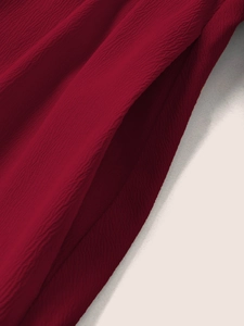 Détail du tissu bordeaux texturé avec motifs gaufrés pour robe de style français
