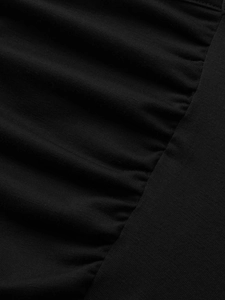 Detail shot of black knitted fabric with elegant ruching and textured draping