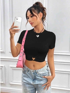 Détail d'un crop top noir avec une découpe unique en forme de cœur au niveau de l'ourlet